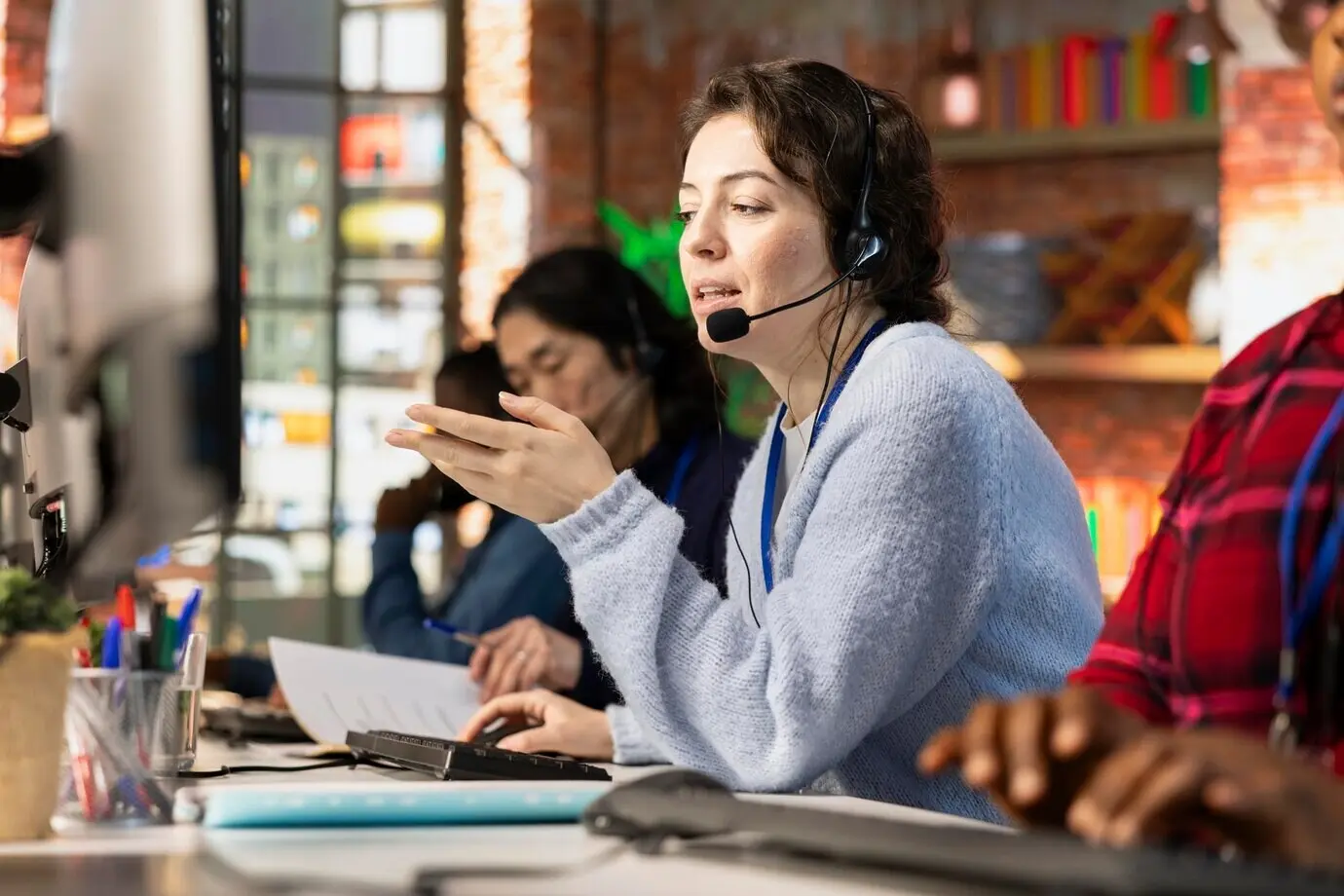 Оператор колл-центра рядом с коллегами, работающими с расстроенными клиентами.